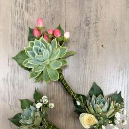 Three succulent boutonnieres with small roses and pink berry accents