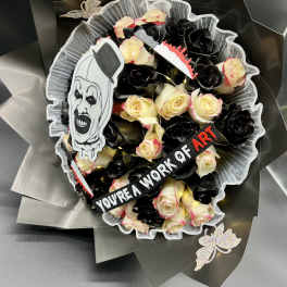 Bouquet of cream and black roses with horror clown decoration and a ribbon reading you’re a work of art.