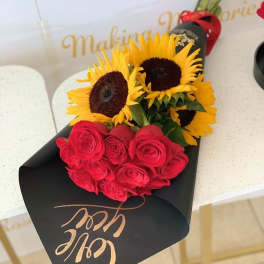 Bouquet of red roses and yellow sunflowers wrapped in black paper