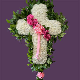 White floral cross with pink roses and ribbon on a purple background