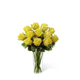 Dozen yellow roses arranged in a clear glass vase.