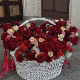 Large white basket filled with red and pink roses