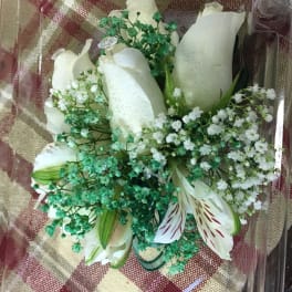 Bouquet of white roses and lilies with small white filler flowers