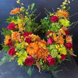 Two autumn floral arrangements with pumpkins and roses