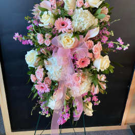 Pink and white floral standing spray with a ribbon bow