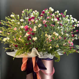 Large mixed bouquet of pink, white, and magenta carnations in a pink hatbox