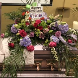 Floral casket spray with roses, hydrangeas, and lilies