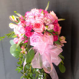 Pink rose bouquet with a large pink ribbon and trailing greenery