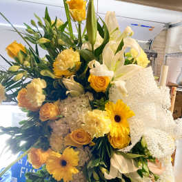 Large bouquet of yellow and white flowers with a white mesh ribbon