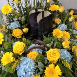 Yellow roses and daisies arranged around black boots