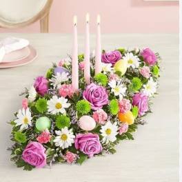 Pink and purple floral centerpiece with three taper candles