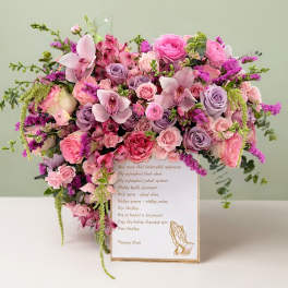 Pink and lavender floral arrangement on a card box with a praying hands illustration
