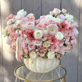 Large pastel bouquet of roses and ranunculus in a white vase