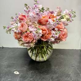 Pink and peach bouquet in a round glass vase