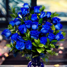 Blue roses arranged in a purple glass vase