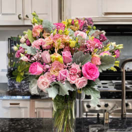 Large pink and peach bouquet in a clear glass vase