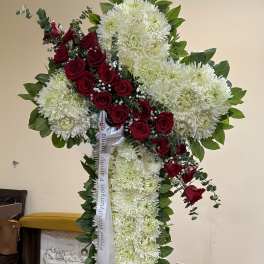 Standing funeral spray of white chrysanthemums and red roses on a metal easel