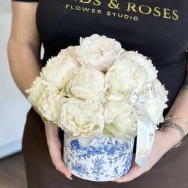 White peonies arranged in a blue-and-white round box with a ribbon