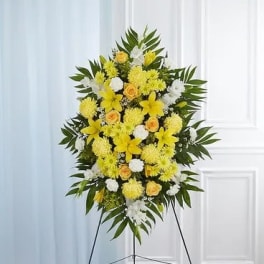 Standing floral spray with yellow and white flowers on an easel