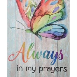 Decorative sign with a colorful butterfly and the words "Always in my prayers" on a wood-style background