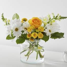 Yellow rose and white daisies in a clear glass vase