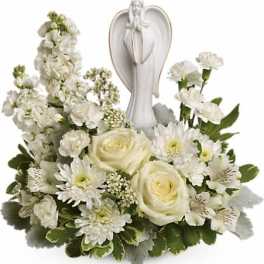 White floral arrangement with angel figurine centerpiece
