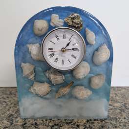 Blue decorative clock with seashells on a tabletop
