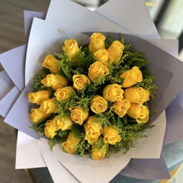 Bouquet of yellow roses wrapped in white paper