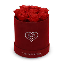 Red roses arranged in a round velvet box with a heart logo