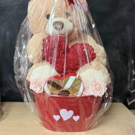 Teddy bear gift basket with red roses and chocolates in a red container
