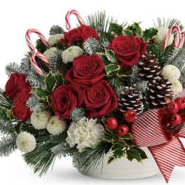Christmas bouquet of red roses with pinecones and candy canes in a white container