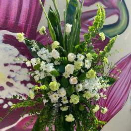 Tall white floral standing arrangement with green accents
