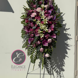 Tall standing floral spray with pink and purple blooms on an easel
