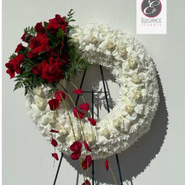 Circular floral wreath with red and white roses on a stand