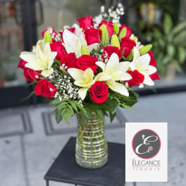 Red roses and white lilies arranged in a glass vase