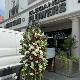 Tall standing floral spray with red and white roses on an easel
