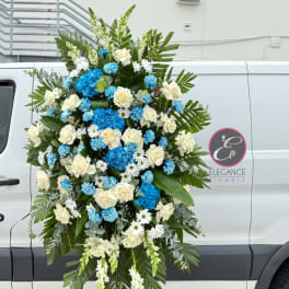 Large standing floral spray with white roses and blue hydrangeas