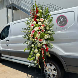 Tall floral standing spray with red, white, and green blooms