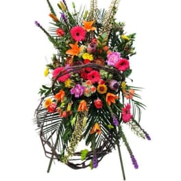Tall colorful standing floral spray with mixed blooms on a wire easel