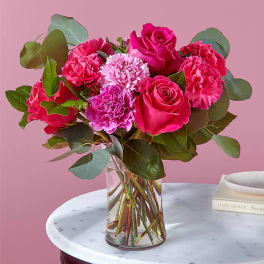 Pink roses and carnations in a clear glass vase