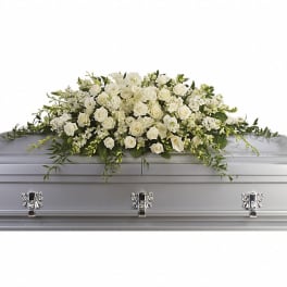 White floral casket spray on a silver casket