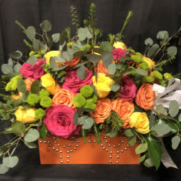 Bright mixed rose arrangement in an orange studded box