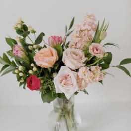 Bouquet of pink and peach roses in a clear glass vase