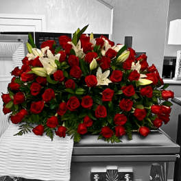Red roses and white lilies arranged on a silver casket