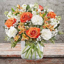 Bouquet of orange and white flowers in a clear glass vase