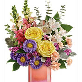 Mixed bouquet in a pink glass vase with yellow roses and purple daisies