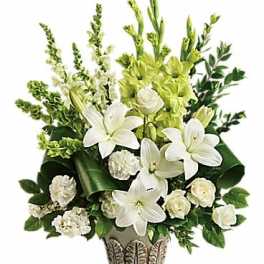 White lilies and green flowers arranged in a decorative vase