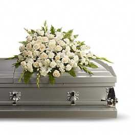 White floral spray on top of a gray casket