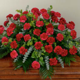 Large red carnation arrangement on a wooden casket