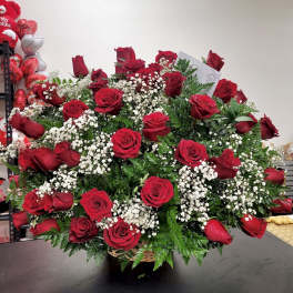 Large bouquet of red roses with white baby's breath in a basket